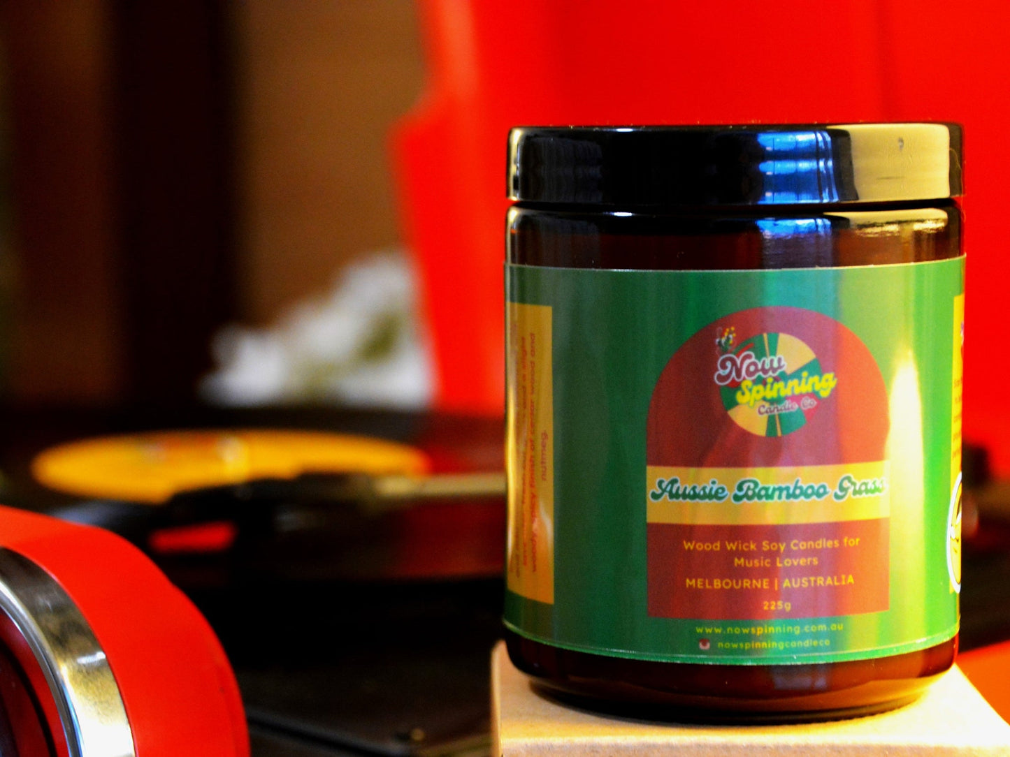 Aussie Bamboo Grass candle with colorful label on a wooden surface