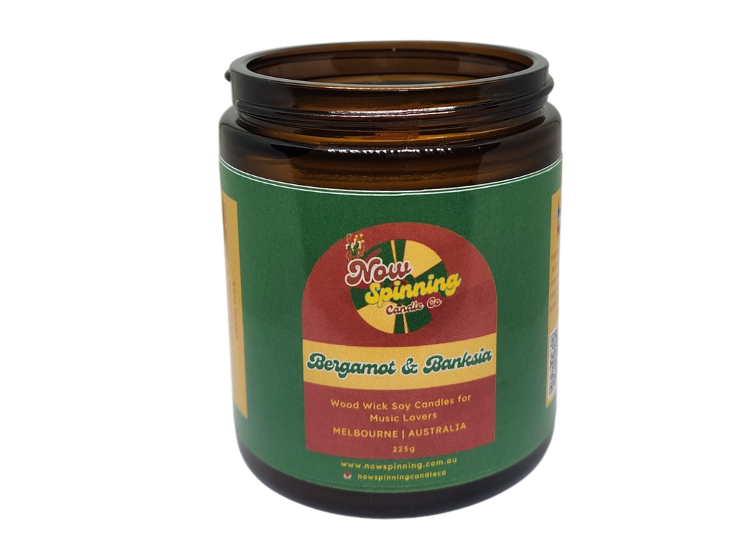 Brown candle jar with a green label featuring a colorful logo on a white background