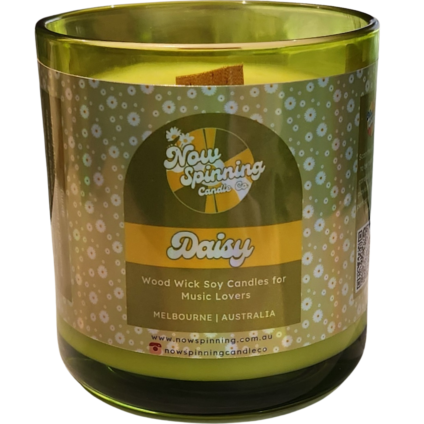 Green candle with a decorative label on a white background