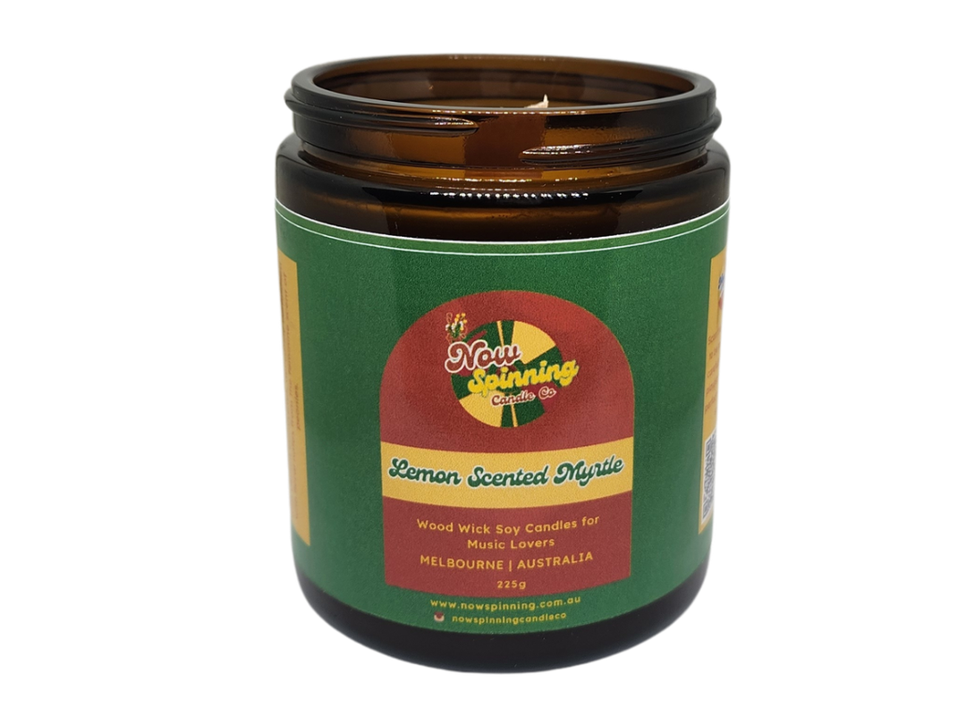 Candle in a brown jar with a green label on a white background
