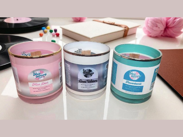 Three scented candles with labels on a surface