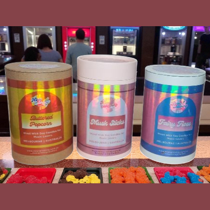 Three colorful containers with labels on a counter.