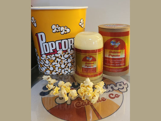 Popcorn bucket, popcorn container, and popcorn on a branded surface, candle