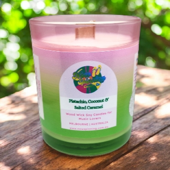 Candle with a colorful label on a wooden surface with a blurred green background