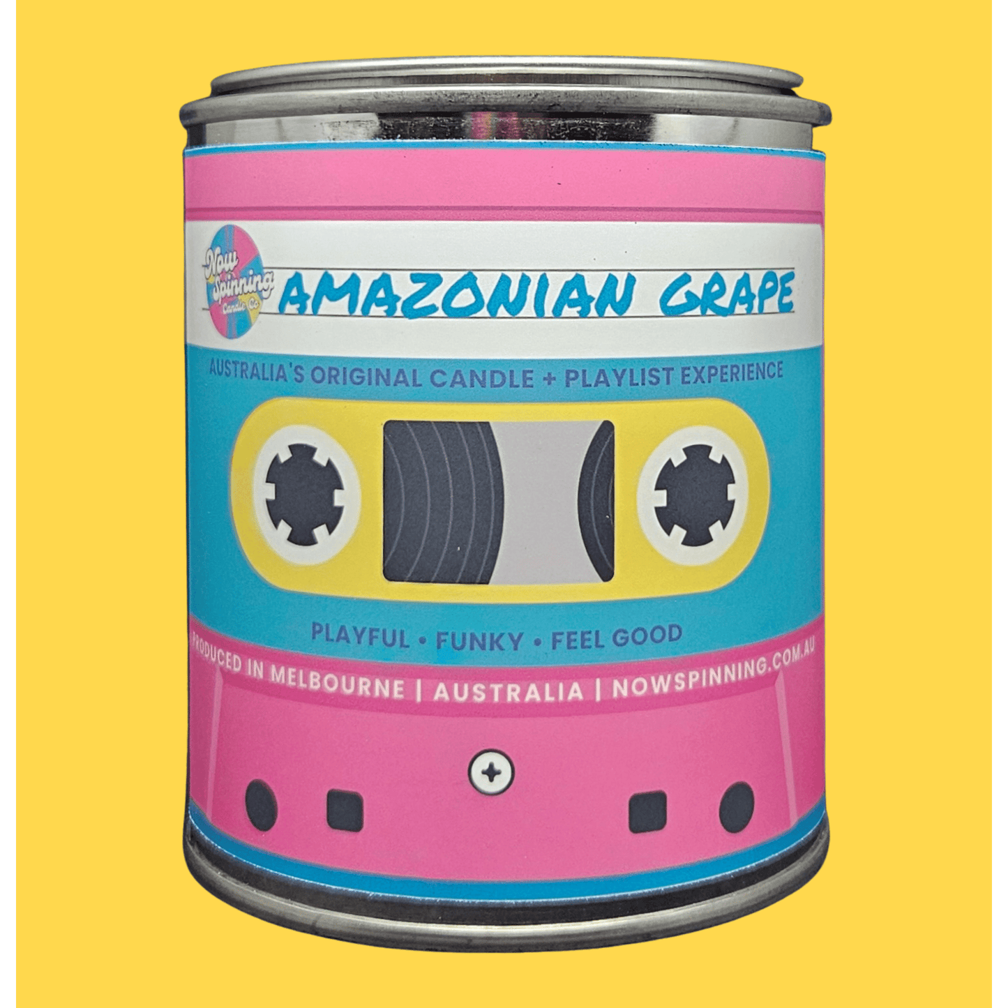 A novelty candle tin styled like a retro cassette tape, featuring a pink and light blue label with the text 'AMAZONIAN GRAPE' and 'Australia's Original Candle + Playlist Experience' on a solid yellow background.