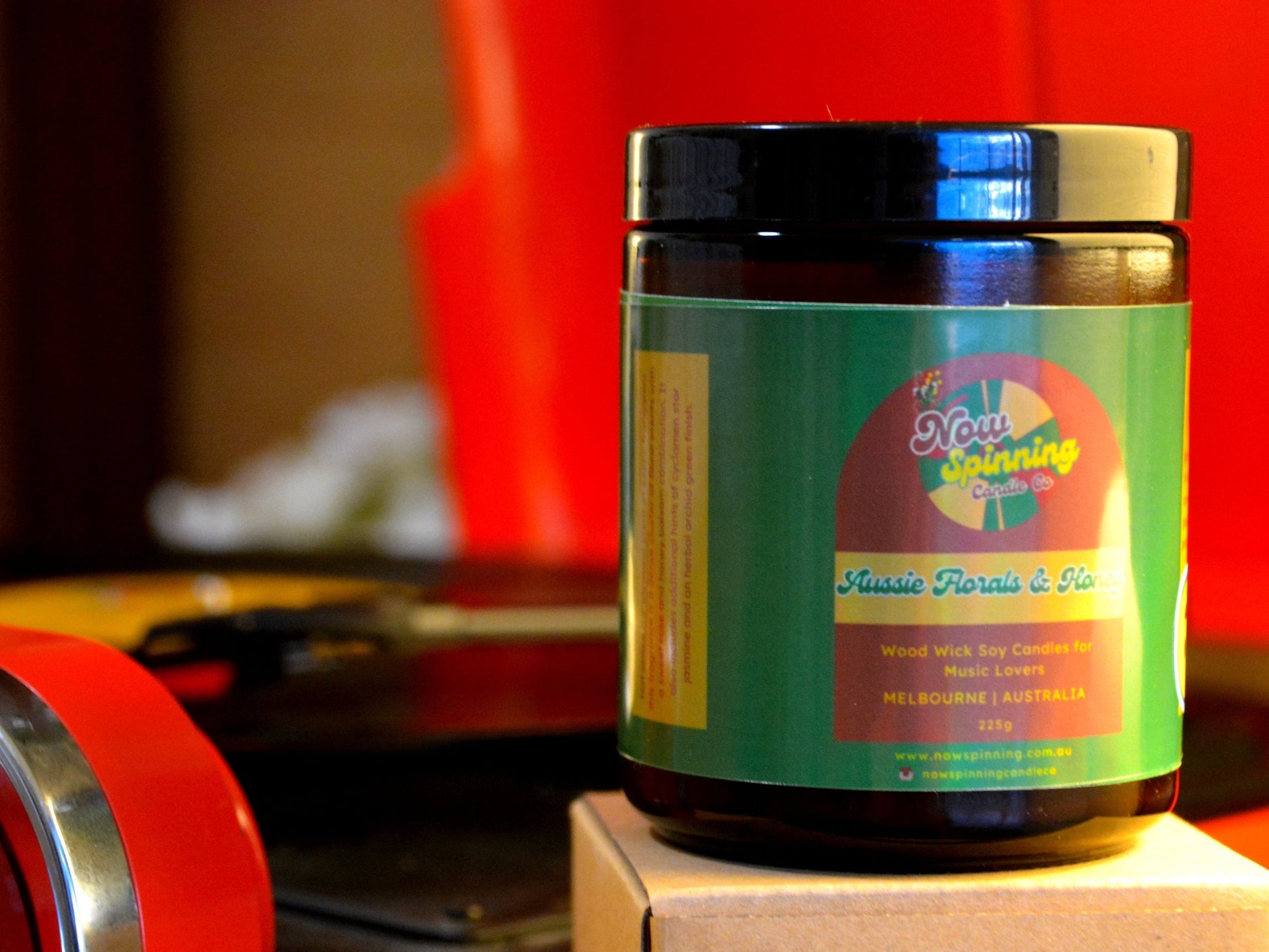 Jar with a colorful label on a wooden block against a red background