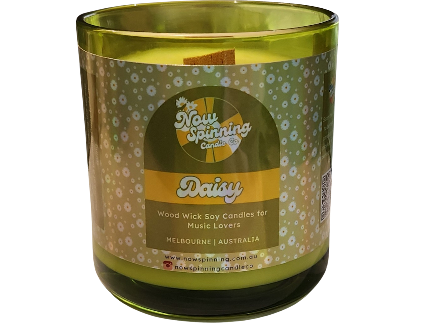 Green candle with a decorative label on a white background