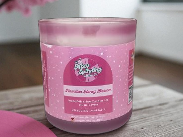 Pink candle with a label on a wooden surface