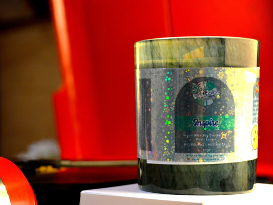 Candle with a label on a white surface against a red background