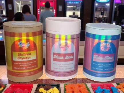 Three colorful  containers with labels on a counter.