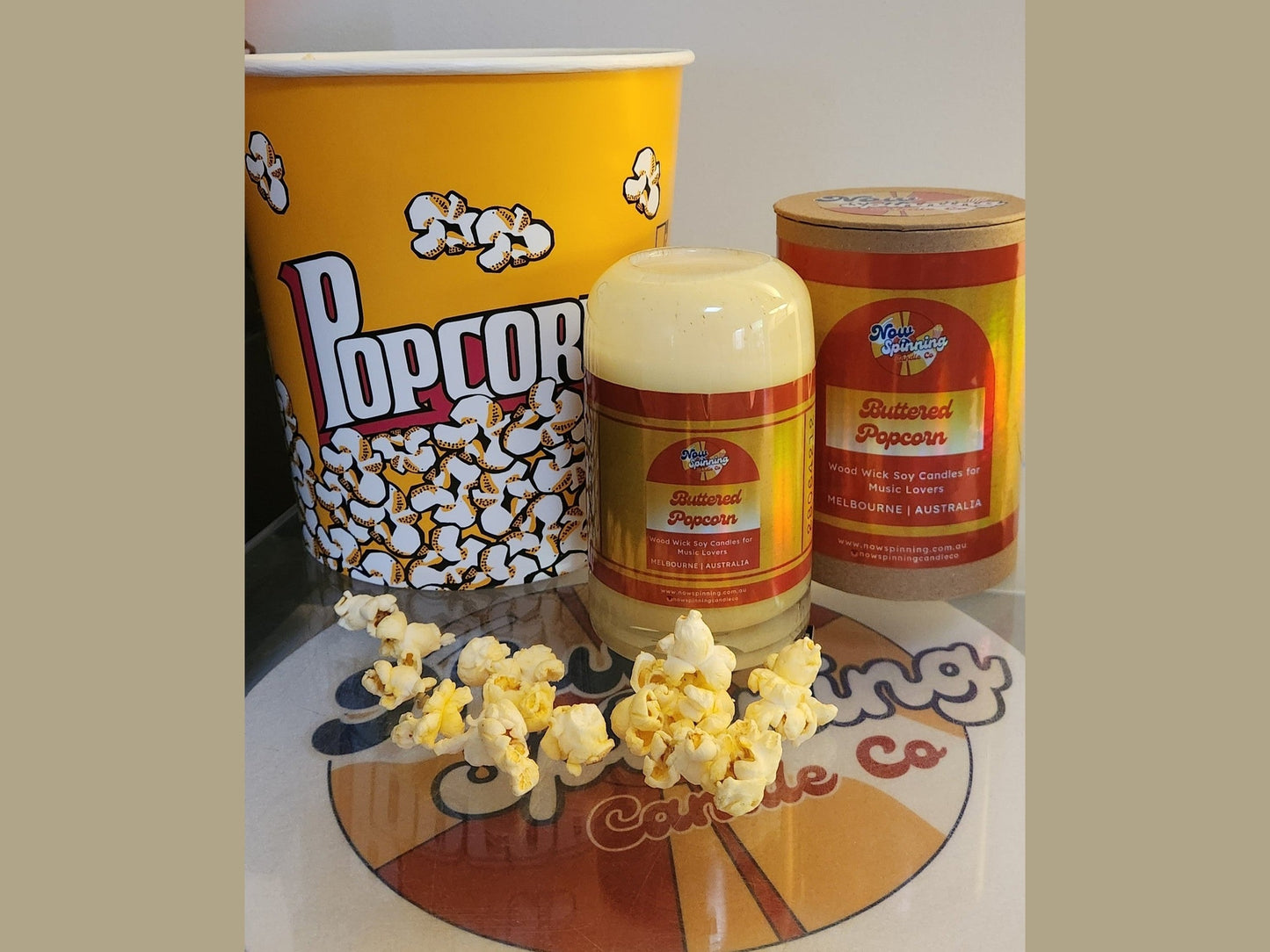 Popcorn bucket, popcorn container, and popcorn on a branded surface, candle