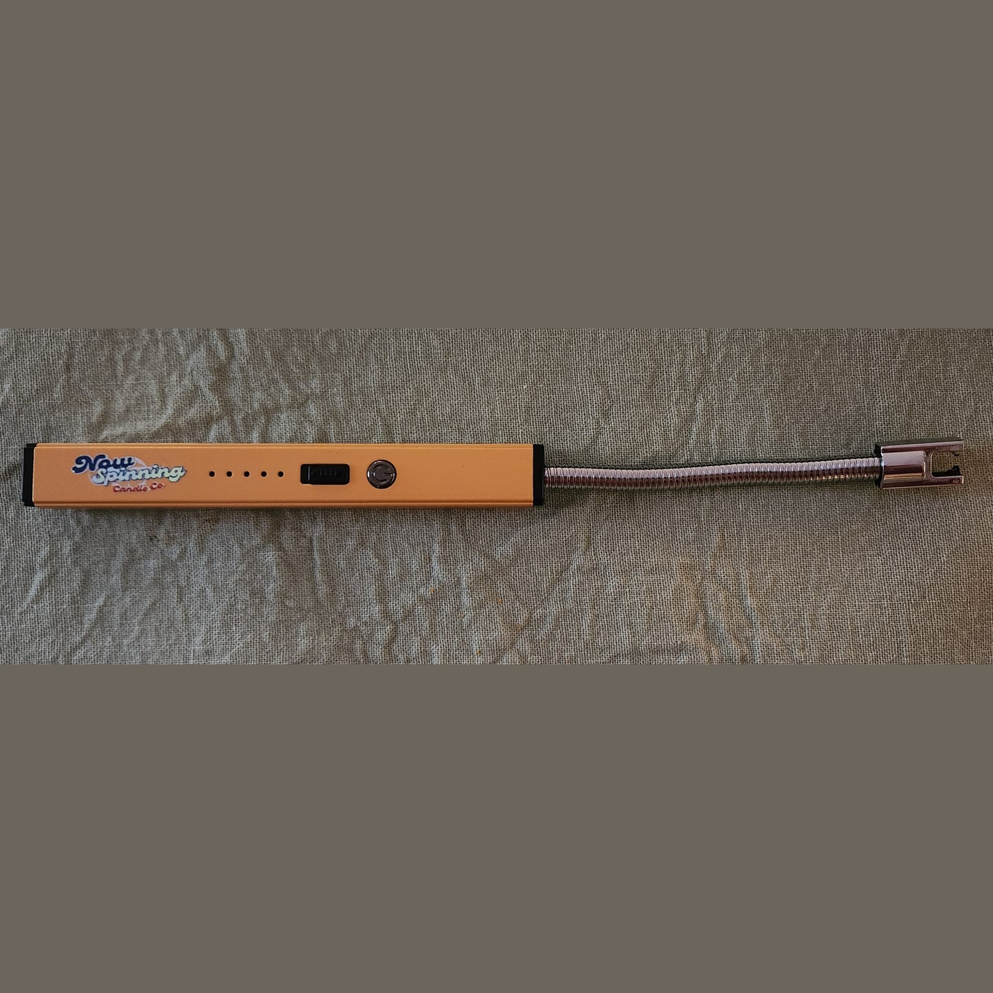 Orange electronic device with a coiled cable on a textured gray surface