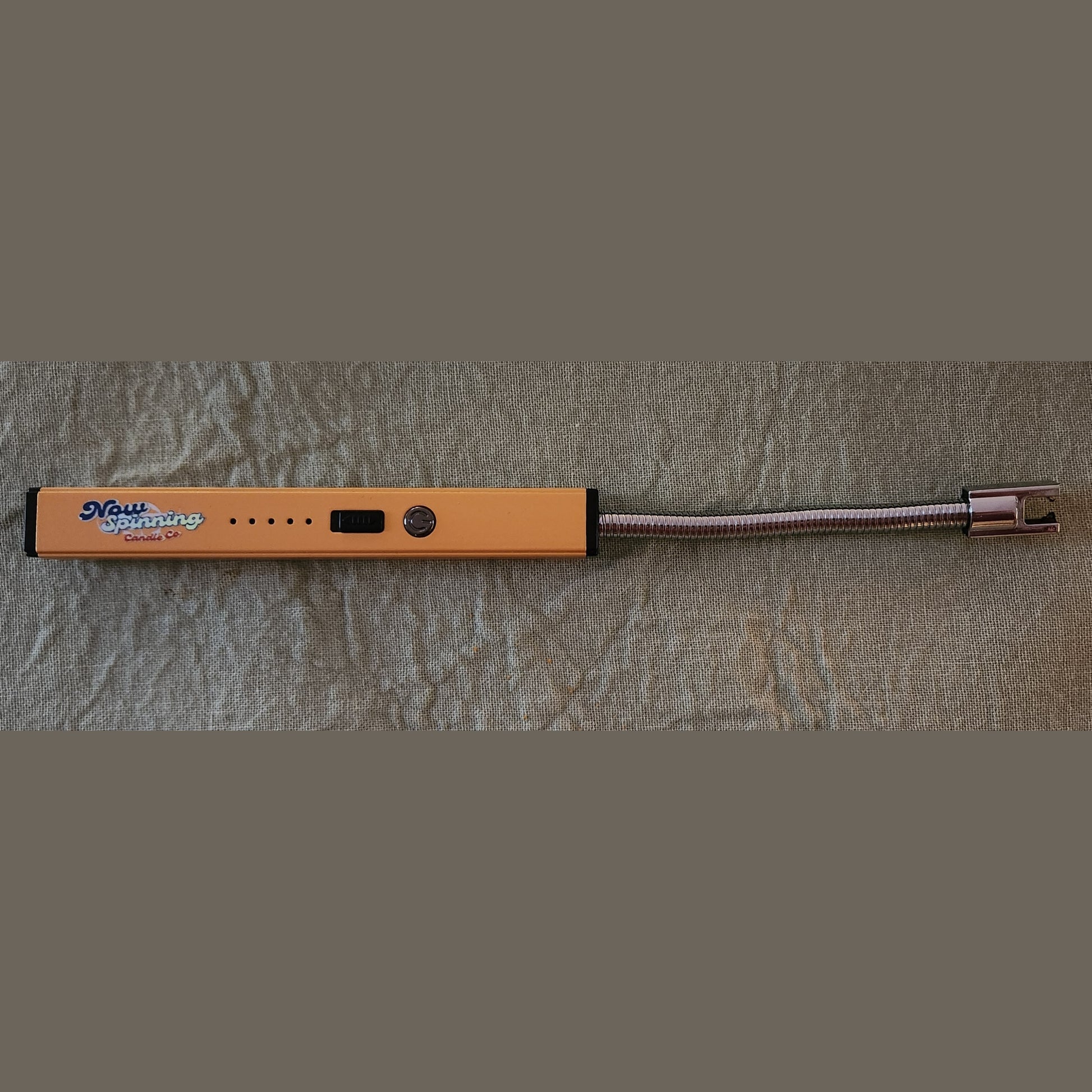 Orange electronic device with a coiled cable on a textured gray surface