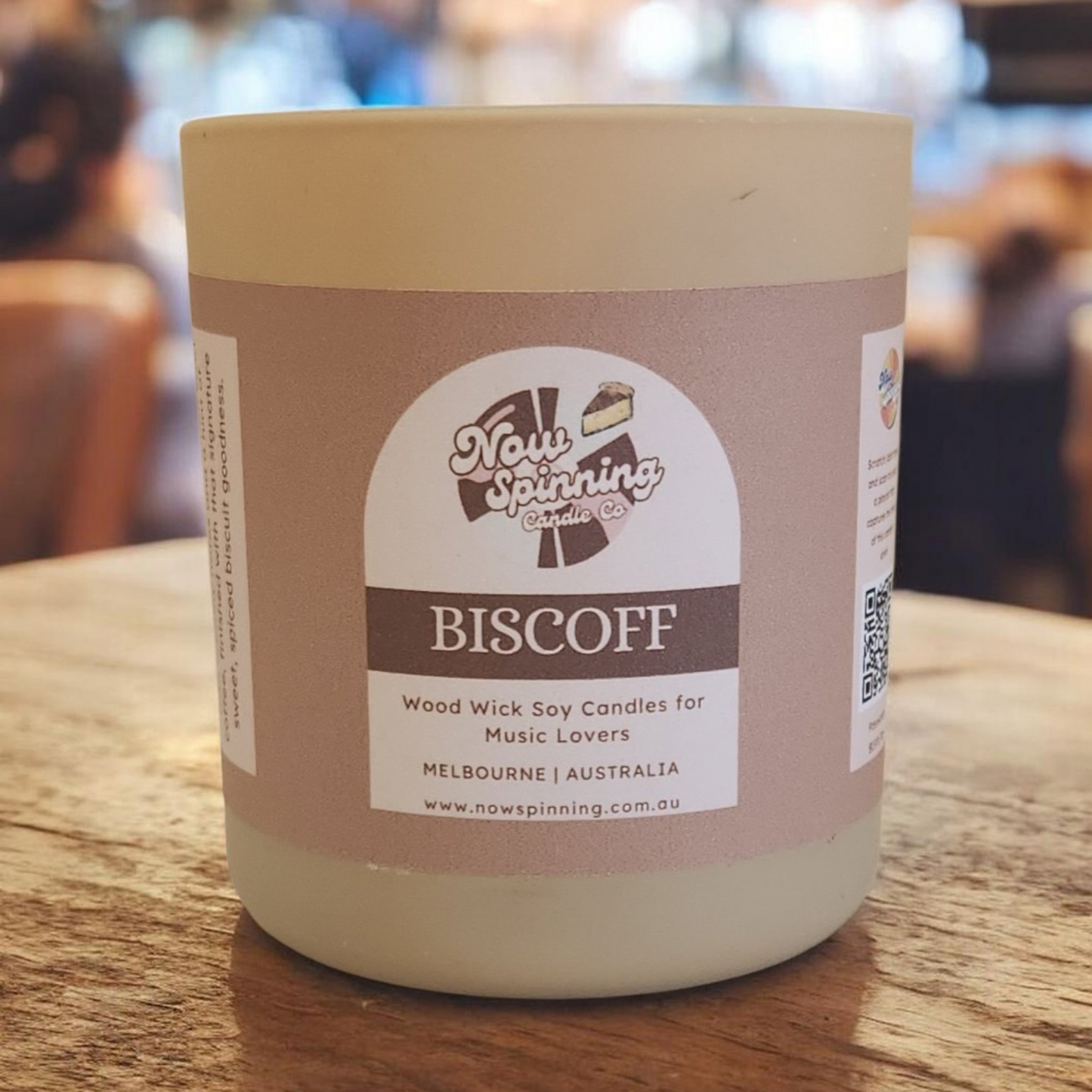 Candle in a jar with a label on a wooden surface
