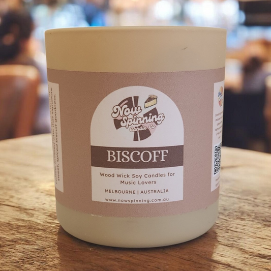 Candle in a jar with a label on a wooden surface
