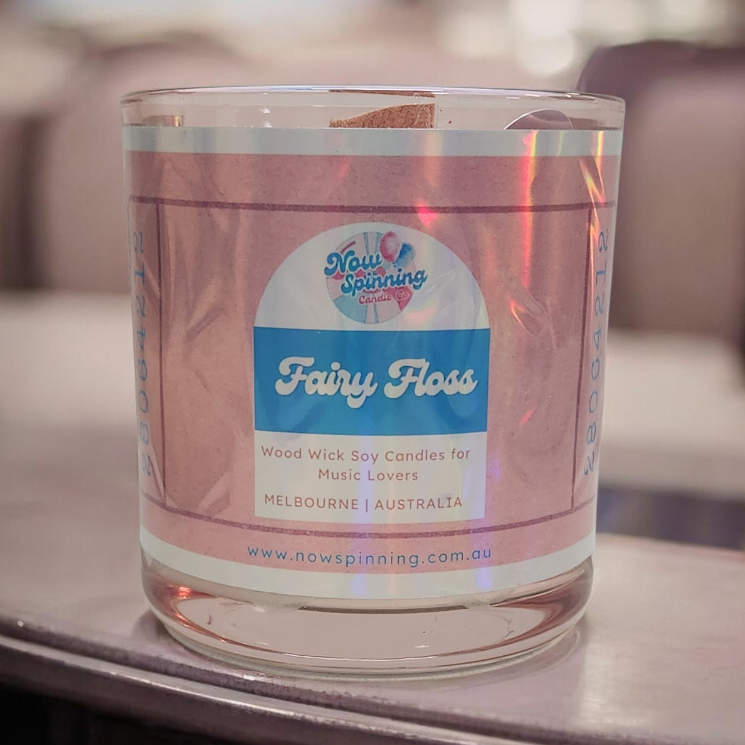 Candle in a glass jar with a label on a blurred background