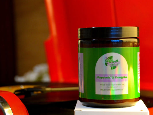 Jar with a green label on a white surface against a red record player