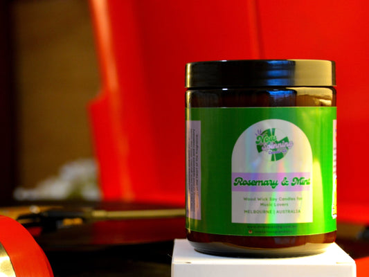 Jar of 'Rosemary & Mint' candle on a white surface with a red record player