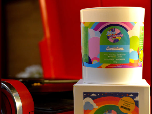 Colorful candle with a label on a white box against a red background