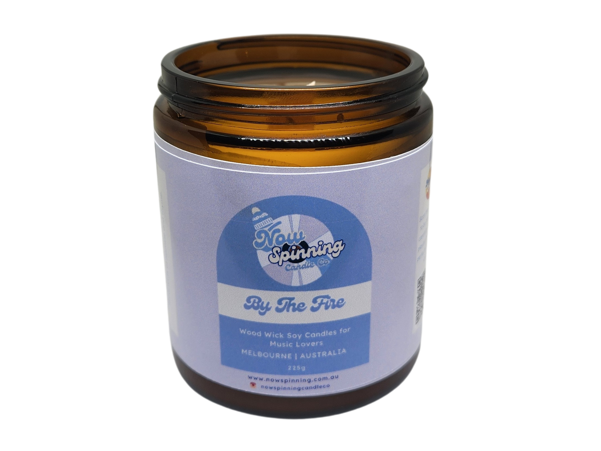 By The Fire Candle in an amber jar with a label on a white background