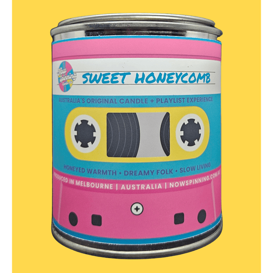 A novelty tin candle designed to look like a retro cassette tape, featuring a pink and cyan label with the text 'SWEET HONEYCOMB' and 'Australia's Original Candle + Playlist Experience'.