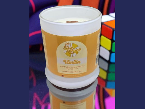 Vanilla scented candle in a white container with a colorful background