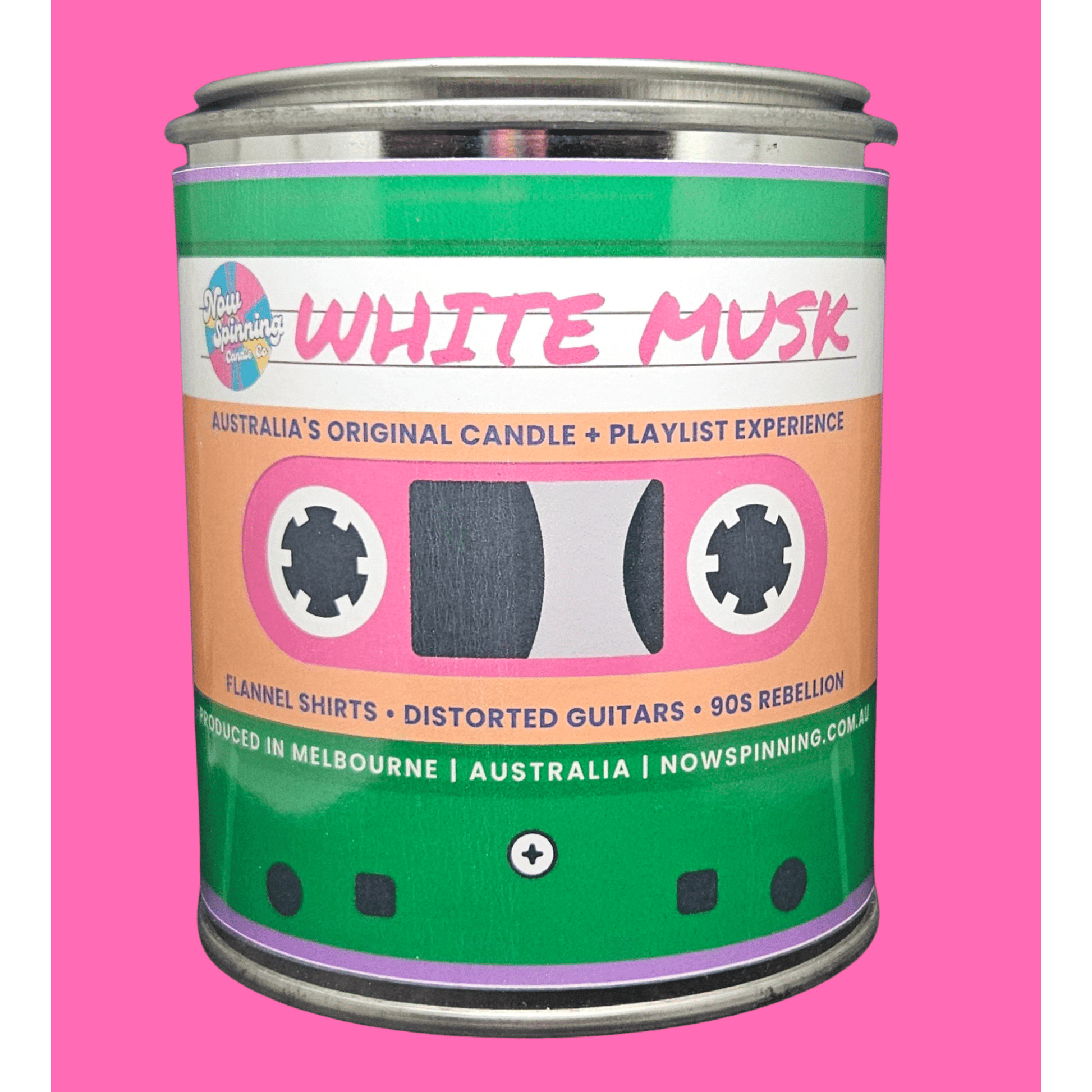 A novelty tin candle labeled 'White Musk' with a cassette tape design, featuring green, pink, and peach colors, set against a solid pink background.